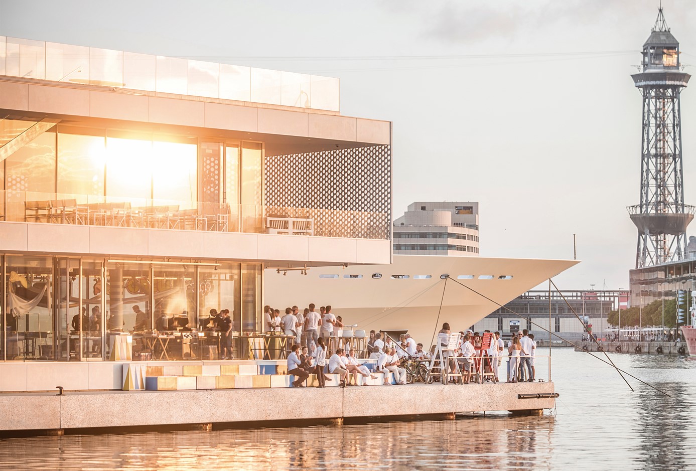 Guests on the waterfront terrace at sunset